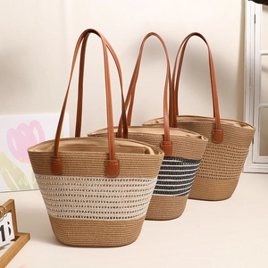 Three striped straw tote bags with leather straps displayed in a warm lifestyle setting