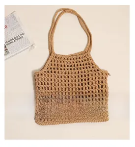 Détail de la texture en maille de coton crocheté creux sur un sac cabas beige