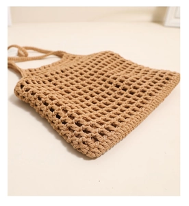 Détail à plat d'un sac cabas en coton beige au crochet avec texture à motif de grille