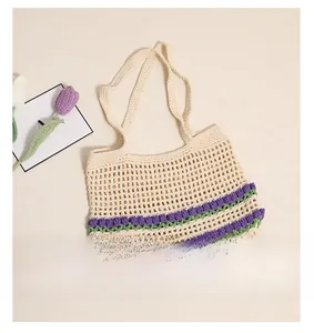 Détail d'un sac à bandoulière au crochet crème avec motifs de tulipes mauves et maille ajourée