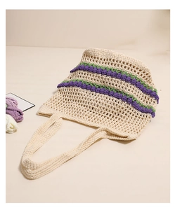 Détail d'un sac cabas en maille crochet beige avec motifs ajourés et touches violettes