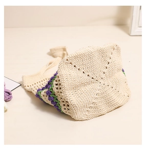 Gros plan d'un sac cabas en crochet fait main crème avec motifs tulipes mauves