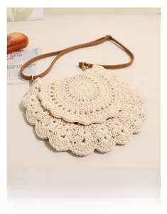 Detail of a handmade semi-circular crochet bag with scalloped edge and brown strap