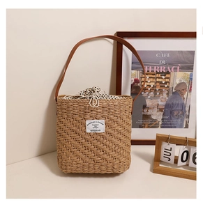 Detail of square straw tote with polka dot drawstring liner and leather shoulder strap