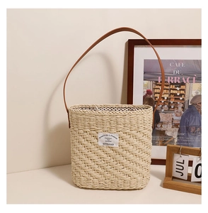 Detail of square straw shoulder bag with leather strap and American Lifewear logo label