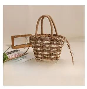 Detail of woven straw bucket bag showing striped pattern and drawstring closure