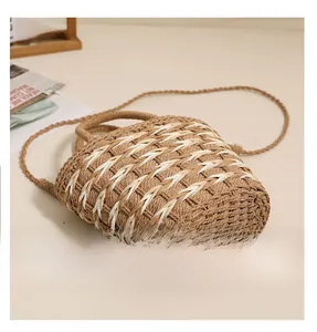 Detailed macro shot of the woven base and dual-tone texture of this straw beach bag