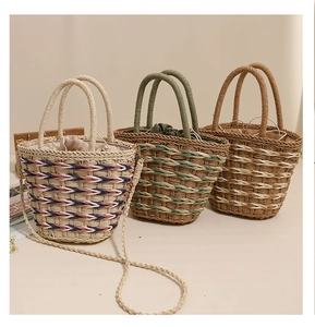 Detailed view of handmade woven straw bucket bags in three colors with drawstring liner