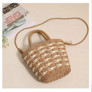 Top-down view of woven straw bucket bag with round handles and crossbody strap
