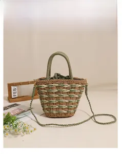 Detail of green straw bucket bag showing woven pattern, drawstring liner and round handle