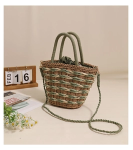 Detail of woven straw basket bag featuring olive green drawstring liner and dual straps