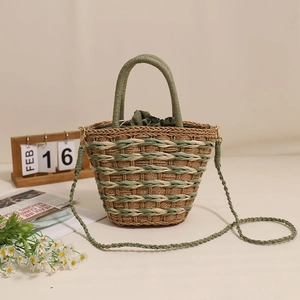 Handmade straw bucket bag in green and natural weave with round handles and crossbody strap