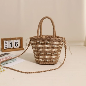 Handcrafted cylindrical straw crossbody bag with dual handles and drawstring closure