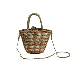 Handwoven straw bucket bag with green handles and secure drawstring liner for summer vacation