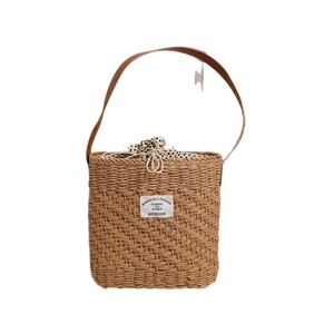 Square brown straw shoulder bag with leather strap and polka dot drawstring lining
