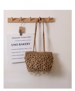 Detail of hollowed flower pattern on handmade brown straw shoulder bag for summer beach