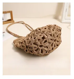 Detailed bottom view of straw bag showing hollow floral weave and inner lining