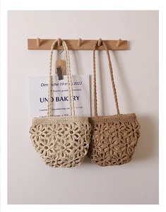Close-up of hand-woven straw bags with hollow floral patterns in cream and tan colors