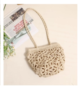 Detail of handmade crochet straw bag featuring hollow floral pattern for summer beach