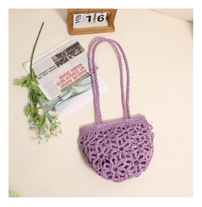 Detail of purple handmade crochet shoulder bag featuring intricate hollow floral patterns