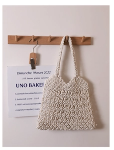 Dettaglio della trama in cotone traforato e del motivo floreale 3D sulla borsa color crema