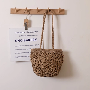 Handmade hollow flower straw shoulder bag in light brown for summer beach vacations