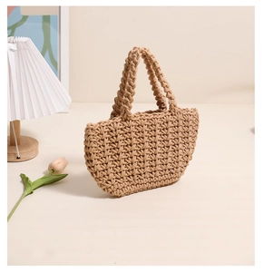 Close-up of hand-woven cotton thread beach bag with shell shape and woven handles