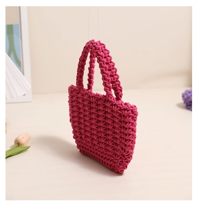 Close-up of vibrant rose pink hand-woven cotton rope handbag with dense honeycomb texture