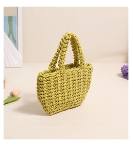 Close-up of handmade yellow woven cotton rope bag with thick texture and dual handles