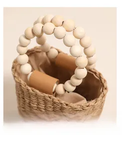 Detailed view of handmade woven straw bag featuring double row light wood bead handles