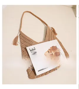 Detail of hollow woven shoulder bag in light coffee cotton thread with tassel accents