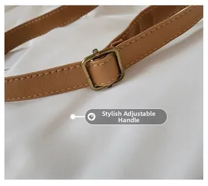 Close-up of brown leather adjustable strap with bronze metal buckle and neat stitching
