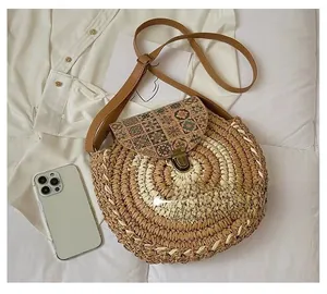 Detail of round straw crossbody bag with spiral weaving and vintage floral lid texture