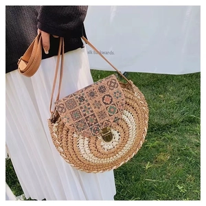 Close-up of woven straw crossbody bag with cork flap featuring vintage mandala patterns