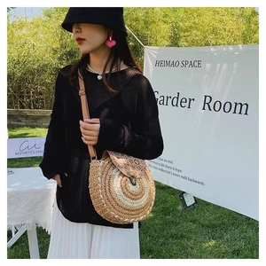 Detail of round straw crossbody bag with floral pattern flap and adjustable strap