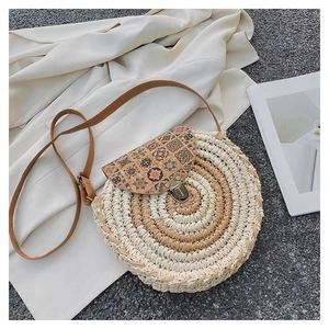 Detail of round straw bag featuring ethnic floral print flap and metal twist lock