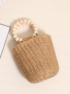 Handmade straw bucket bag with beaded handles and wooden accents for summer beach beach