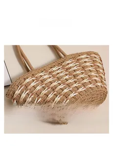 Detail showing the intricate woven texture and two-tone contrast of the straw beach bag
