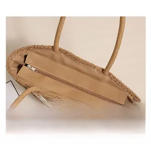 Close-up of the smooth metal zipper closure and fabric lining on a straw tote bag