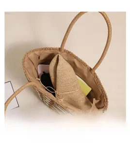 Interior view showing the large capacity of the straw tote bag with personal items