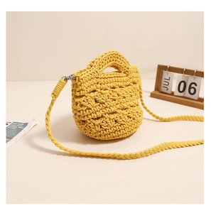Detail of yellow hand-knitted cotton crossbody bag with hollow floral pattern