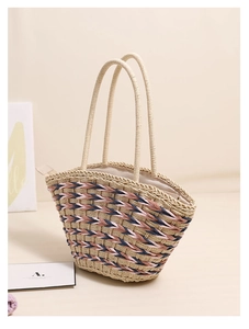 Detailed macro view of woven straw texture with pink and blue stripe accents on beach bag