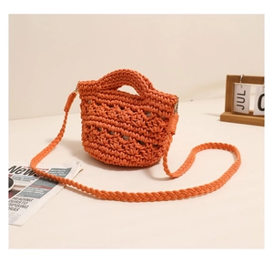 Detail of hand-woven orange crochet crossbody bag featuring thick cotton yarn texture