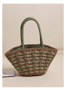Close-up of woven straw tote bag featuring green stripes and durable shoulder straps
