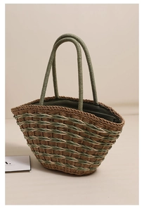 Detail of woven straw shoulder bag with green and brown fibers and interior lining
