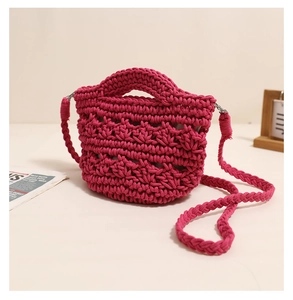 Close-up of rose pink hand-woven cotton bag with hollow wave pattern and braided strap