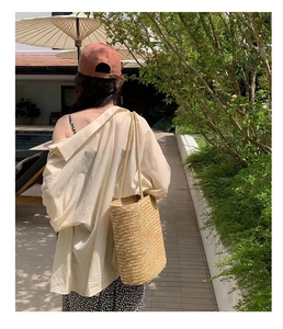 Detail of straw woven tote bag with long handles for summer beach vacations