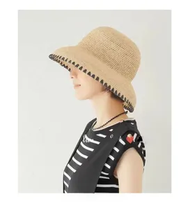 Detail of hand-woven raffia sun hat featuring vintage geometric black patterned edges
