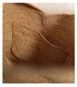 Detailed macro view of the interior woven texture and inner pocket of the raffia bucket bag