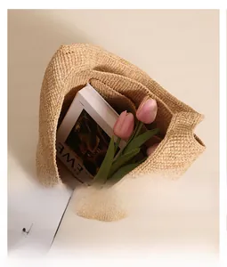 Top view of large straw tote bag showing spacious interior with books and flowers